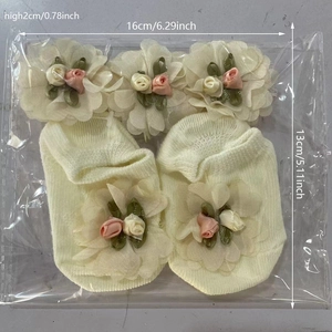 Detalle de set de regalo para bebé con diademas de flores de gasa y calcetines