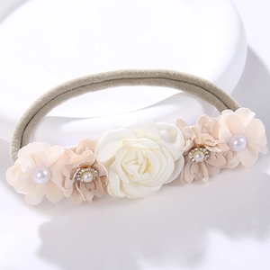 Detail of floral baby headband with silk roses, pearls, and rhinestones on soft elastic