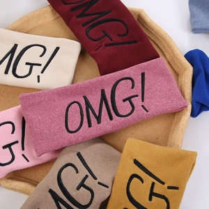 Detail of colorful knit hairbands with OMG embroidery in a decorative display tray