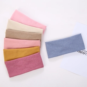 Close-up of seven elastic knitted headbands in assorted colors with soft fabric texture