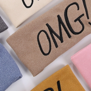 Detailed macro view of soft knitted headbands with diverse colors and OMG embroidery