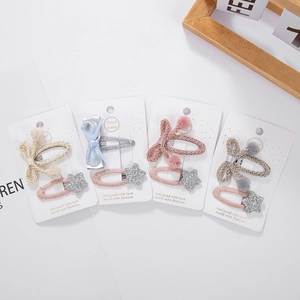 Détail de barrettes à cheveux tissées avec nœuds et étoiles à paillettes pour enfants