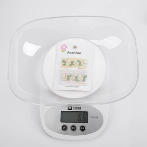 Vue de barrettes à broderie marguerite de 6,6g sur une balance pour vérifier le poids