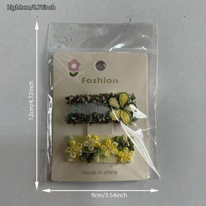 Détail de barrettes à fleurs en dentelle brodée sur une carte de présentation de 12x9cm