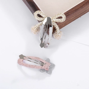 Détail de la barrette à cheveux nœud tressé avec pompon et pince étoile à paillettes