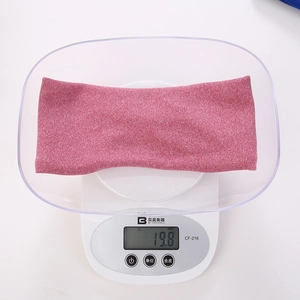 Pink knit face washing headband weighing 19.8g on a digital scale for accuracy