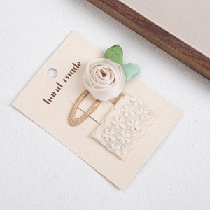 Detailed macro view of handmade rose fabric hair clip and floral lace embroidery set