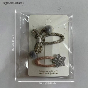 Détail de barrettes à cheveux tissées avec pompons et étoiles scintillantes sur carte