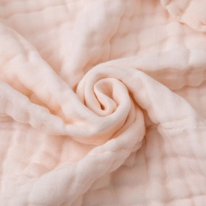 Close-up of soft pink 6-layer bamboo cotton gauze fabric with breathable bubble texture