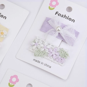 Gros plan sur une barrette en dentelle brodée à la française avec fleurs et nœud perlé