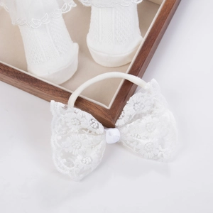 Detailaufnahme von Baby Stirnband mit Spitzenschleife und passenden Mesh-Söckchen Set