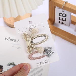 Détail des barrettes tressées avec nœud et étoile et pompons doux pour filles