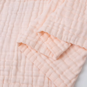 Close-up of soft pink 6-layer muslin cotton baby towel with breathable bubble texture