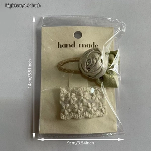 Detailed view of 3D rose and lace floral hair clips in clear packaging with paper backing