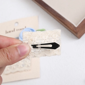 Detailed back view of a handmade lace embroidery BB hair clip with floral patterns