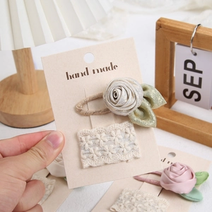 Detail of handmade fabric rose hair clip and lace BB clip set on premium paper card