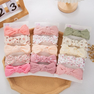 Detail view of 15 cotton baby headbands with floral bows and solid colors set