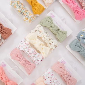 Detailed close-up of 5-pack baby headbands with soft floral cotton and knit textures