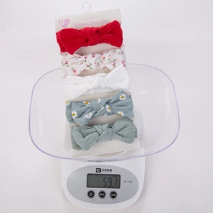 Detail showing five-piece baby headband set on white card scale weighing 59.1 grams