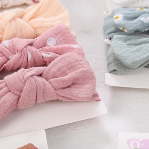 Detail of soft muslin cotton baby bow headbands in various floral and solid colors