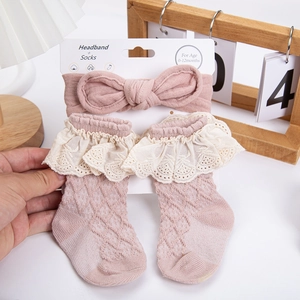 Close-up of pink baby headband and lace socks set for 0-12 months old infants