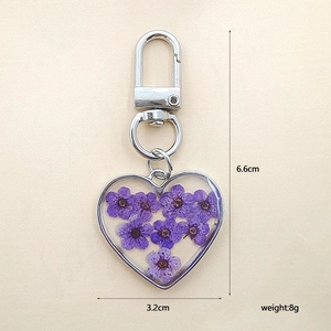 Detail view of heart-shaped dry flower keychain with dimensions 6.6cm by 3.2cm and weight 8g