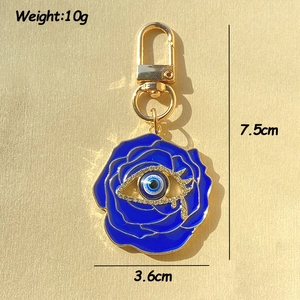 Detail view of French vintage rose evil eye keychain with blue enamel and gold finish