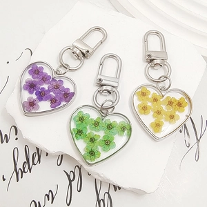 Handmade heart-shaped resin keychain with colorful dried flowers and golden lobster clasp
