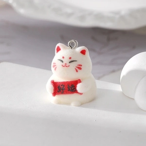 Macro shot of white flocked lucky cat keychain pendant with Good Luck scroll detail