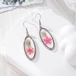 Boucles d'oreilles ovales argentées avec de vraies fleurs séchées roses en résine claire