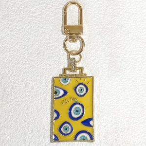 Détail macro du porte-clés en émail jaune avec l'inscription gravée I SEE YOU élégante