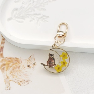 Golden crescent moon keychain with resin cat silhouette and yellow dried flowers charm