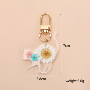 Detailed macro view showing real dried flowers inside a resin cat-shaped keychain charm