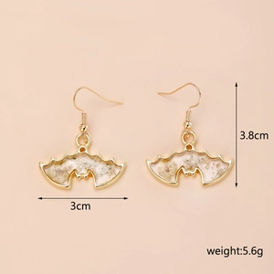 Détails de boucles d'oreilles chauve-souris dorées avec pétales blancs et dorures