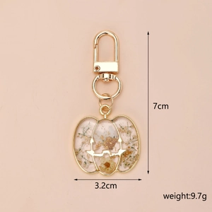 Detail view of pumpkin dried flower keychain showing 7cm height and golden resin finish