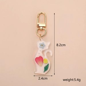 Detailed view of cat-shaped resin keychain with dried flowers and dimensions info