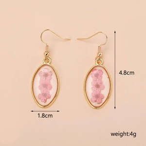 Dettaglio degli orecchini con fiori secchi rosa, cornice dorata e misure del prodotto