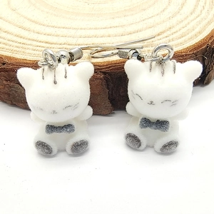 Detail of white flocked cartoon cat earrings with cute black whiskers and silver hooks