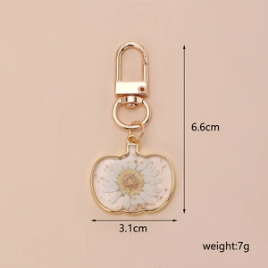 Detailed view of dried daisy pumpkin keychain with gold foil and dimensions 6.6x3.1cm