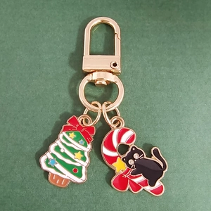 Detail of Christmas cat candy cane and tree pendants on gold alloy keychain