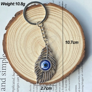Détail du porte-clés plume œil protecteur, longueur 10,7 cm et poids de 10,8 g