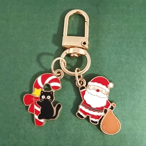 Detail of Christmas cat candy cane and Santa Claus enamel keychain with gold lobster clasp
