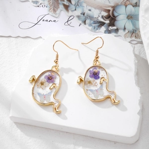 Boucles d'oreilles fantôme avec cadres dorés et fleurs sur fond de pierre blanche