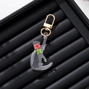Creative resin cat keychain with real red and green dried flowers inside a gold metal clasp
