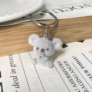 Close-up of cute grey flocked koala keychain with green leaf detail and silver ring