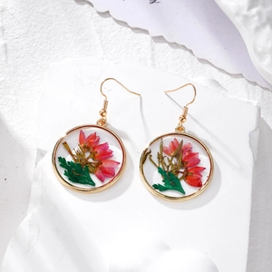 Handmade gold circular drop earrings featuring real pink dried flowers in clear resin