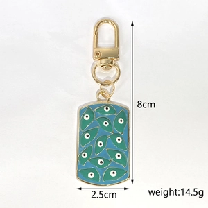 Detailed view of the 8cm gold evil eye keychain with blue and green enamel rectangle pendant