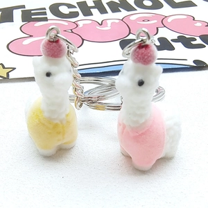 Cute flocked alpaca keychains in pink and yellow with colorful vests and metal rings