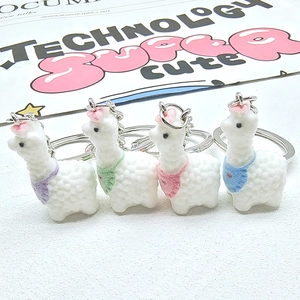 Set of four cute flocked alpaca keychains with colorful scarves and metal rings