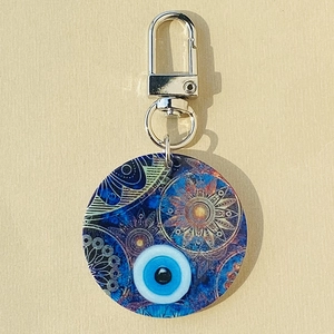 Detail of evil eye mandala keychain with blue tribal pattern and silver metal clip